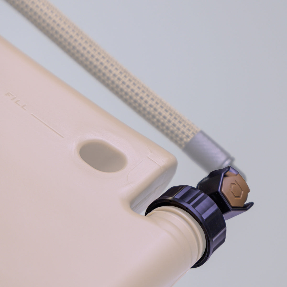 Bottom-up view of ICECAP Gen 3 attached to ICEPLATE Gen 3 in Coyote Brown with hydration tube, demonstrating thread compatibility; ICECAP highlighted with rest of image greyed out.