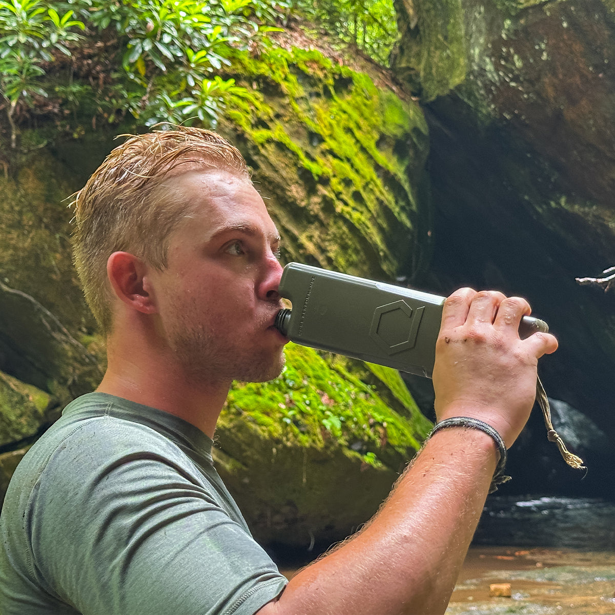 Man drinking from ICEFLASK canteen in nature background.