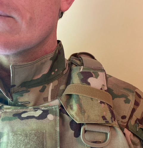 Close-up of man's shoulder wearing a tactical vest with ICEVENTS shoulder pad attachment.